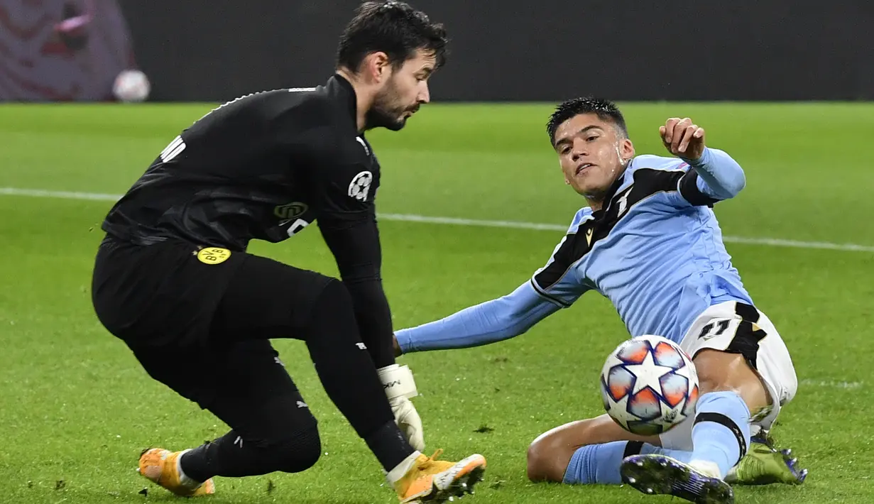 Kiper Borussia Dortmund, Roman Buerki (kiri) melakukan penyelamatan di depan gelandang Lazio, Joaquin Correa pada matchday kelima Grup F Liga Champions di Signal Iduna Park, Dortmund, Kamis (3/12/2020) dinihari WIB. Borussia Dortmund cuma berimbang 1-1 dengan Lazio. (AP Photo/Martin Meissner, Pool)