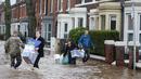 Warga menyelamatkan barang mereka saat banjir merendam wilayah Warwick Road Carlisle, Inggris, Minggu (6/12). Puluhan ribu rumah tidak punya listrik karena Badai Desmond yang menyebabkan banjir di Inggris utara dan sebagian Skotlandia (REUTERS/Phil Noble)