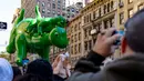 Balon dinosaurus hijau besar melayang di atas jalan saat Parade Hari Thanksgiving Macy.  (AP Photo/Peter K. Afriyie)