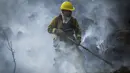 Seorang petugas pemadam kebakaran memadamkan api dengan sikat di Capilla del Monte, Cordoba, Argentina (15/10/2020). Selama berminggu-minggu, petugas pemadam kebakaran telah bekerja secara intensif memadamkan api di provinsi Córdoba, di Argentina tengah. (AP Photo/Mario Tizon)