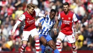Pemain Arsenal Martin Odegaard (kiri), berduel memperebutkan bola dengan pemain Brighton Danny Welbeck dalam pertandingan lanjutan Liga Inggris di Stadion Emirates, Sabtu (9/4/2022) malam WIB. (AP Photo/Ian Walton)