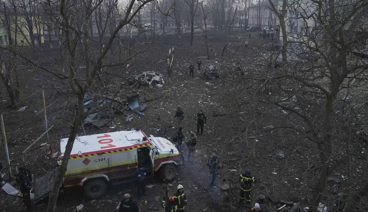 Pekerja darurat Ukraina bekerja di sisi rumah sakit bersalin yang rusak akibat serangan udara di Mariupol, Ukraina (9/2/2022). Serangan Rusia telah merusak parah sebuah rumah sakit bersalin di kota pelabuhan Mariupol yang terkepung, kata pejabat Ukraina. (AP Photo/Evgeniy Maloletka)