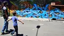 Warga melihat mural karya seniman selama Festival Aliados di San Jose, Costa Rica (11/3). Acara festival seni ini dimeriahkan oleh 50 seniman dari 10 negara. (AFP Photo/Ezequiel Becerra)