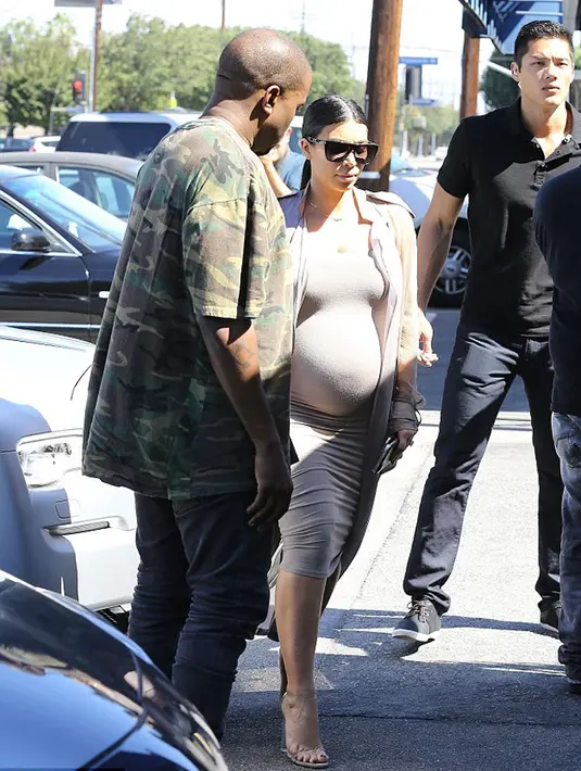 Suami tercinta, Kanye West terlihat menemani sang istri di siang hari yang cerah itu. Mereka menanti kelahiran bayi di dalam perut Kim pada Desember mendatang. (via dailymail.co.uk)