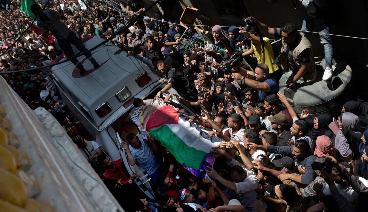 Pelayat membawa jasad perawat Palestina, Razan Najjar saat pemakamannya di Kota Khan Younis, Jalur Gaza Selatan, Sabtu (2/6). Razan ditembak tentara Israel saat memberi pertolongan pada korban luka di tengah demonstrasi di Gaza. (AP Photo/Khalil Hamra)