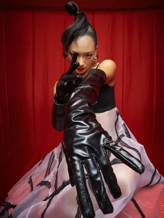 Ia mengenakan one strap dress hitam putih dengan rok A-Line semi transparan. Dipadukan dengan leather gloves dan aksesori yang lebih futuristik. [@theleonardi]