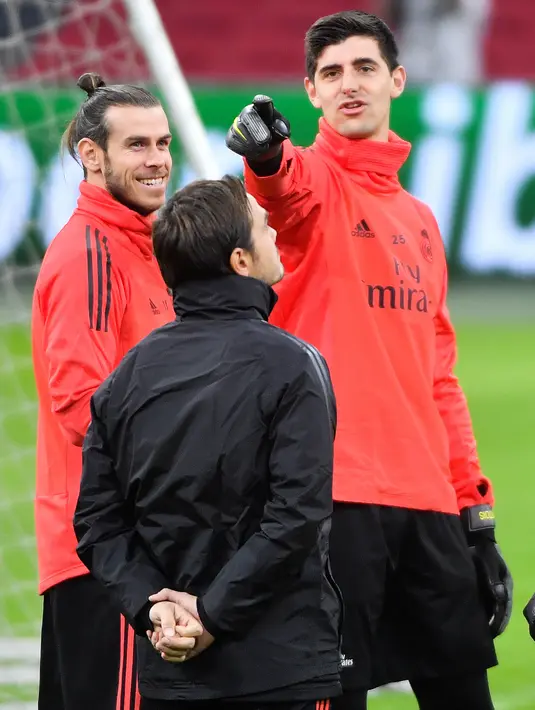 Pemain Real Madrid Gareth Bale (kiri) berbincang dengan Thibaut Courtois saat sesi latihan jelang menghadapi Ajax Amsterdam pada babak 16 besar Liga Champions di Johan Cruijff Arena, Amsterdam, Belanda, Selasa (12/2). (EMMANUEL DUNAND/AFP)