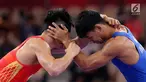 Pegulat putra Indonesia, Muhammad Aliansyah dan Zhang Gaoquan dari China saling mengunci saat bertarung pada kelas putra 67 Kg Asian Games 2018 di arena gulat JCC Senayan, Selasa (21/8). (Liputan6.com/Fery Pradolo)