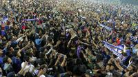 Lautan manusia memenuhi area lapangan Stadion Kanjuruhan, Malang, pada Jumat (12/4/2019) malam. Para pemain Arema FC dikerubuti Aremania yang bersuka cita tim kesangannya juara Piala Presiden 2019. (Bola.com/Yoppie Renato)