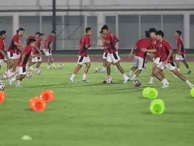 Pesepak bola Timnas Indonesia U-23 melakukan pemanasan saat mengikuti sesi latihan bersama di Stadion Madya, Kompleks Gelora Bung Karno, Senayan, Jakarta, Kamis (17/7/2025). (Liputan6.com/Helmi Fithriansyah)