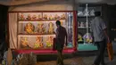 Orang-orang melihat patung dewa Hindu berkepala gajah Lord Ganesha yang dipajang di sebuah bengkel menjelang festival Ganesh Chaturthi di Mumbai (12/8/2021). Festival Ganesh Chaturthi adalah perayaan kelahiran Ganesha, dewa kebijaksanaan, kemakmuran, dan keberuntungan Hindu. (AFP/Punit Paranjpe)