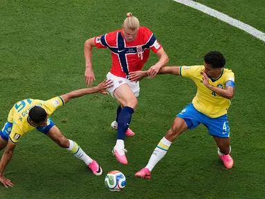 Pemain Norwegia Erling Haaland berebut bola dengan pemain Brasil Douglas Santos dan Marquinhos selama pertandingan sepak bola babak 16 besar Piala Dunia antara Brasil dan Norwegia di East Rutherford, N.J., dekat New York, Minggu, 5 Juli 2026. (AP Photo/Matt Slocum)