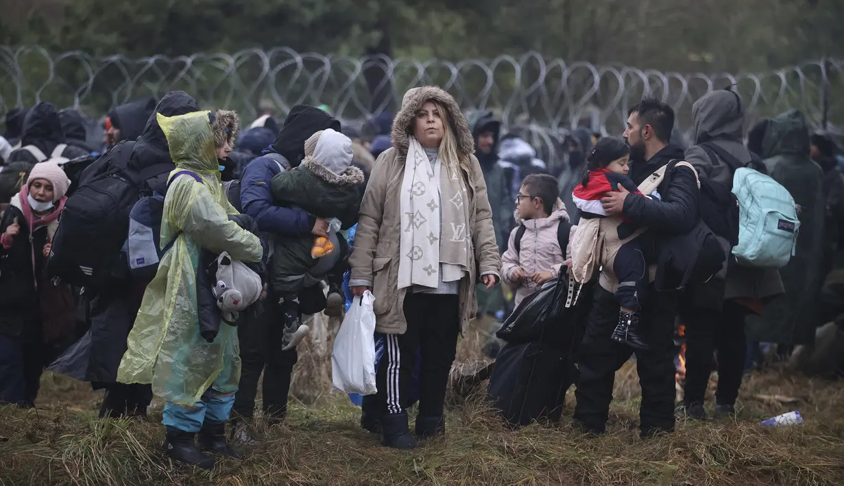Migran dari Timur Tengah dan tempat lain berkumpul di perbatasan Belarus-Polandia dekat Grodno, Belarus, Senin (8/11/2021). Menurut pejabat setempat, Sekelompok besar migran masuk Belarusia tampaknya sedang berkumpul di sebuah titik penyeberangan. (Leonid Shcheglov/BelTA via AP)