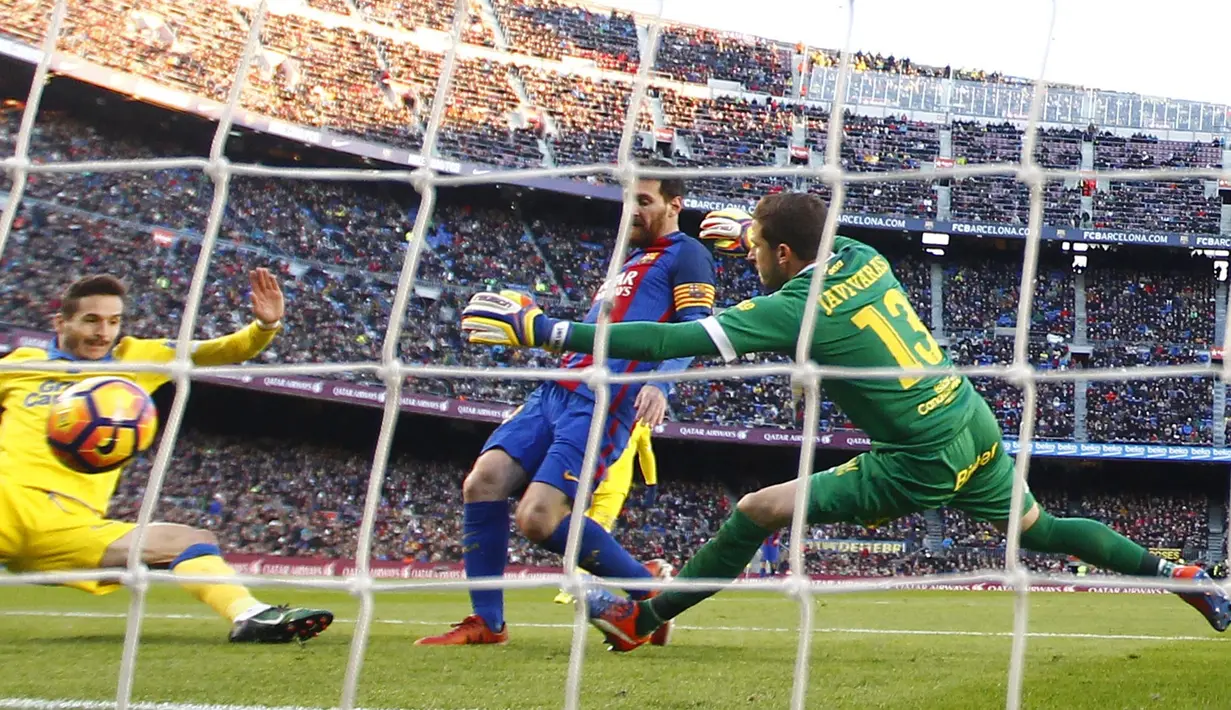 Pemain FC Barcelona, Lionel Messi (tengah) mengecoh kiper dan pemain Las Palmas saat mencetak gol pada laga La Liga di Camp Nou, Barcelona (14/1/2017). Barcelona menang 5-0. (AP/Manu Fernandez)