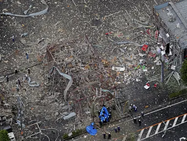 Penyelidik bekerja di lokasi ledakan di Koriyama, Prefektur Fukushima, Jepang utara, Kamis, (30/7/2020). Setidaknya lebih dari puluhan orang terluka dan dibawa ke rumah sakit setelah ledakan akibat kebocoran gas menghantam dinding, jendela, dan bangunan di lingkungan tersebut. (Berita Kyodo via AP)