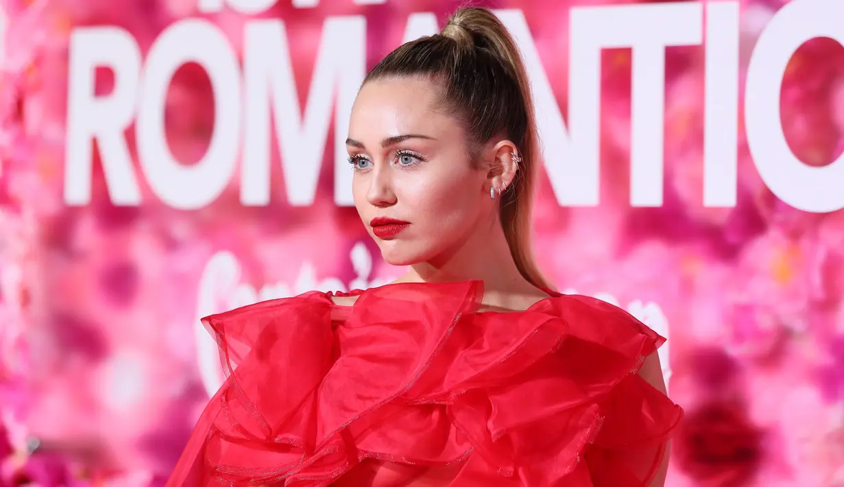 Penyanyi dan artis Hollywood, Miley Cyrus berpose saat tiba menghadiri pemutaran perdana film "Isn't It Romantic" di Los Angeles (11/2). Miley Cyrus tampil memesona dengan gaun berwarna merah Maison Valentino. (AFP Photo/Jean-Baptiste Lacroix)