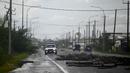 Cabang-cabang pohon terlihat tumbang di jalan setelah Badai Lisa di Belize City, Belize, 3 November 2022. Badai Tropis Lisa menyebabkan banjir dan membuat sebagian negara itu menjadi gelap gulita. (Johan ORDONEZ/AFP)