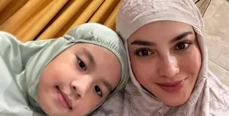 Ririn Ekawati memamerkan potret selfie gemasnya bersama anak perempuan keduanya, mengenakan mukena. Ririn mengenakan mukena berwarna cokelat dengan bordir cantik, sedangkan sang anak memilih mukena hijau pastel yang polos. [Foto: Instagram/ririnekawati]
