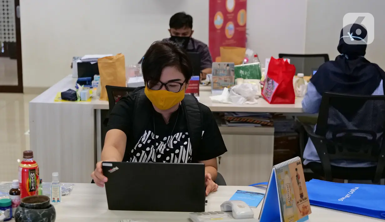 Karyawan membuka laptop sebelum memulai aktivitas bekerja di Suntory Garuda, Jakarta, Senin (8/8/2020). Perusahaan tersebut menerapkan protokol kesehatan saat hari pertama kerja di masa PSBB transisi yang diterapkan oleh Pemprov DKI Jakarta. (Liputan6.com/Herman Zakharia)