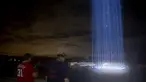 Orang-orang melihat pertunjukan cahaya saat mengunjungi penghormatan ringan untuk serangan 9/11 di Pentagon di Arlington, Virginia (10/9/2020). Pertunjukan tersebut adalah bagian dari peringatan skala kecil tahun ini karena pandemi virus corona. (Tasos Katopodis / Getty Images / AFP)