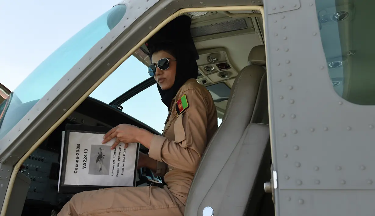 Niloofar Rahmani mengecek buku pesawat saat berada ruang kokpit jet Angkatan Udara Afghanistan di Kabul. Kementerian Pertahanan Afghanistan mengonfirmasi bahwa Niloofar  Rahmani telah mencari suaka ke AS. (AFP PHOTO/SHAH Marai)