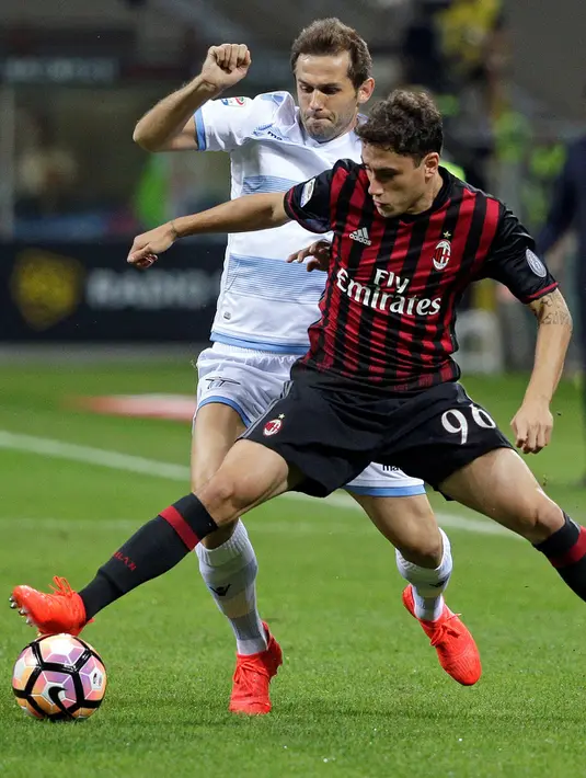 Bek AC Milan, Davide Calabria (kanan) berusaha mengontrol bola dari kejaran bek Lazio, Senad Lulic pada liga Italia di stadion San Siro, Milan, Italia, (21/9). AC Milan menang atas Lazio dengan skor 2-0. (REUTERS/Max Rossi)