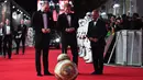 Pangeran William dan Pangeran Harry melihat robot droid BB-8 ketika berjalan di karpet merah premiere film The Star Wars: The Last Jedi yang digelar di The Royal Albert Hall, London, Inggris, Selasa (12/12). (Eddie Mulholland/Pool Photo via AP)