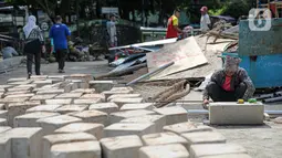 Pekerja menyelesaikan pembangunan revitalisasi Jembatan Cibubur, Jakarta, Senin (24/10/2022). Jembatan Cibubur yang saat ini sedang direvitalisasi, akan dilengkapi akses untuk pejalan kaki. Jembatan Cibubur yang menghubungkan Pasar Rebo dan Ciracas itu akan ditinggikan guna menghindari genangan ketika permukaan Kali Cipinang meninggi dan ditargetkan selesai pada bulan November 2022. (Liputan6.com/Faizal Fanani)
