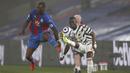 Striker Crystal Palace, Christian Benteke (kiri) berebut bola dengan bek Manchester United, Eric Bailly dalam laga lanjutan Liga Inggris 2020/21 pekan ke-27 di Selhurst Park, Rabu (3/3/202). Crystal Palace bermain imbang 0-0 dengan Manchester United. (AFP/Adrian Dennis/Pool)