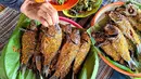 Hasil ikan mas yang telah diasapkan menggunakan kayu bakar di Setu Tujuh Muara Sawangan, Depok, Minggu (19/06/2022). Untuk dapat menikmati ikan asap, pengunjung harus memesan 1-2 hari sebelum dihidangkan karena proses pengasapan ikan yang memakan waktu sekitar 7 jam. (Liputan6.com/Fery Pradolo)