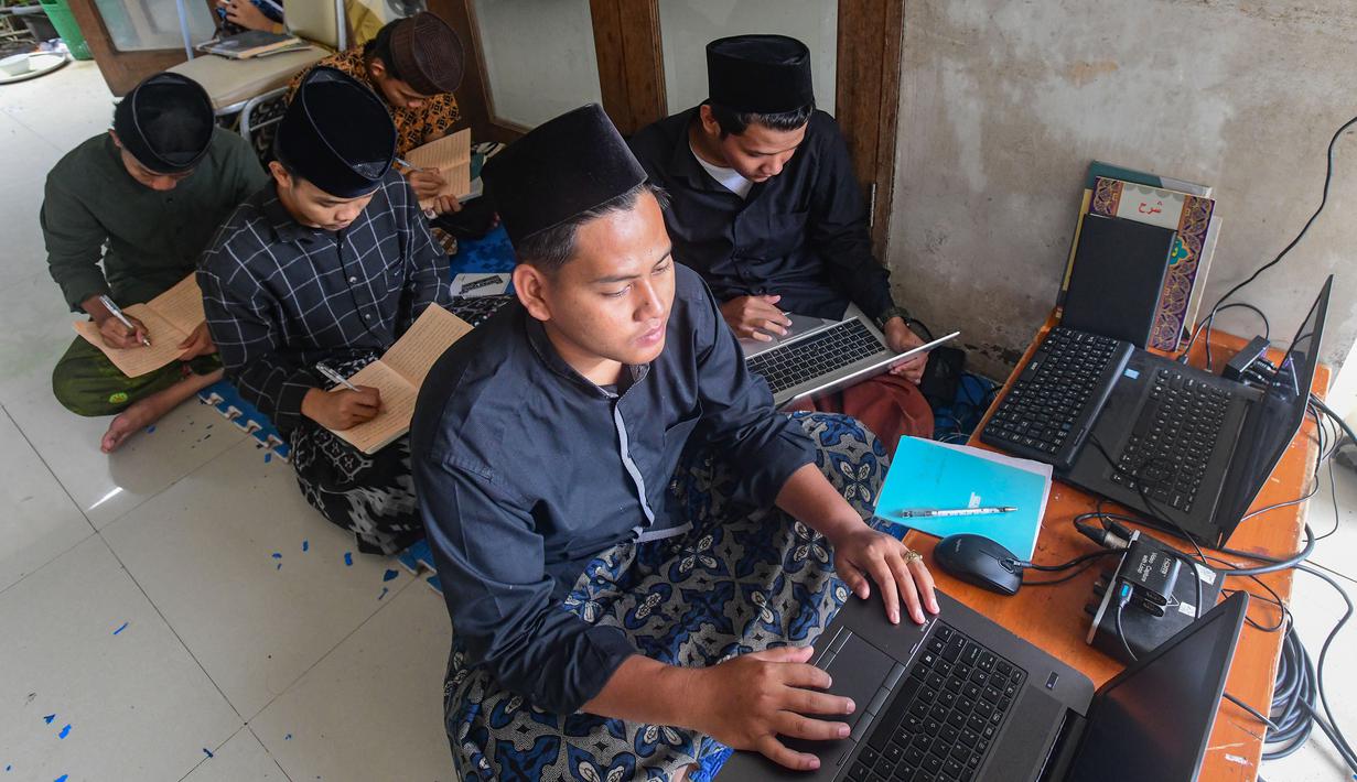 Menggunakan tradisi khas pesantren dalam mengkaji kitab kuning, di mana santri menyimak penjelasan guru untuk memahami makna mendalam dari teks Arab gundul. Tampak dalam foto, para santri saat mengikuti kegiatan belajar mengajar kajian kitab kuning Ayyuhal Walad di Pondok Pesantren (Ponpes) Sirajussa’ Adah di Limo, Depok, Jawa Barat, Kamis (26/2/2026). (merdeka.com/Arie Basuki)