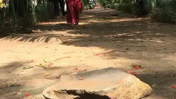 Pejalan kaki melintasi trotoar yang rusak dan berlubang di Jalan Kyai Tapa, Jakarta, Kamis (24/1). Banyaknya lubang akibat kerusakan penutup saluran air tersebut membahayakan pejalan kaki. (Liputan6.com/Immanuel Antonius)