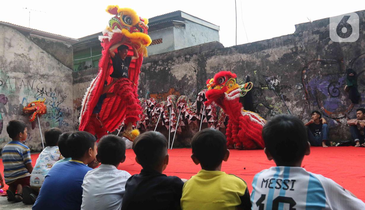 Pemain dari kelompok barongsai Naga Merah Putih Bogor melakukan latihan dengan Barongsai di kawasan Babakan Pasar, Kota Bogor, Jawa Barat, Rabu (11/1/2023). Latihan tersebut  untuk mempersiapkan penampilan menyambut Tahun Baru Imlek. (Liputan6.com/Herman Zakharia)
