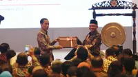 Presiden Jokowi menerima cenderamata dari Ketua KPK, Agus Rahardjo pada peringatan hari Antikorupsi Dunia, Jakarta, Senin (11/12). (Liputan6.com/Angga Yuniar)