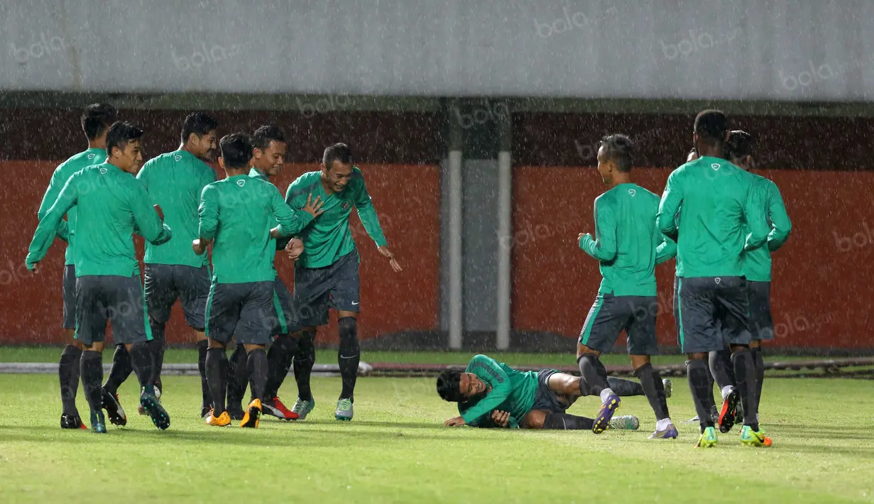 Para pemain Timnas Indonesia bercanda saat hujan deras pada sesi latihan uji coba lapangan di Stadion Maguwoharjo, Sleman, Sabtu (08/10/2016). (Bola.com/Nicklas Hanoatubun)