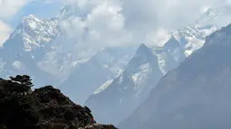 Para pendaki berjalan di sepanjang jalan di Syangboche di wilayah Everest, sekitar 140km timur laut Kathmandu (16/4). (AFP Photo/Prakash Mathema)