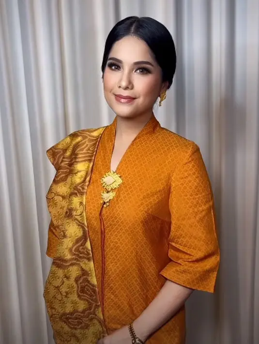 Penampilannya terlihat khas ibu pejabat dengan riasan soft glam dan bros emas [@barry_irawan]