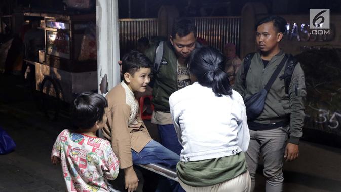 Seorang anak pencari suaka berbincang dengan pewarta di trotoar depan Masjid Ar-Rayan, Jalan Kebon Sirih, Jakarta, Jumat (5/7/2019). Para pencari suaka ini membangun tenda-tenda dan meminta kepastian perlindungan dari UNHCR . (Liputan6.com/Helmi Fithriansyah