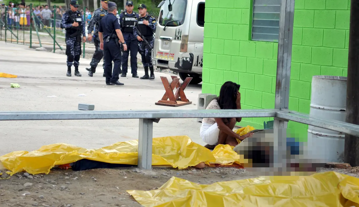 Seorang wanita menangisi jenazah yang tergelatak di jalanan pasca penembakan di terminal bus kota Choloma, Honduras, (24/11). 8 orang tewas akibat penembakan ini. (REUTERS/Stringer)