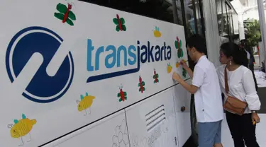 Seorang anak berkebutuhan khusus melukis bus Transjakarta di halaman Balai Kota, Jakarta, Jumat (20/4). Kegiatan tersebut dalam rangka memperingati Hari Kartini. Tema lukisan yang diangkat adalah ‘Ibuku Perempuan Tangguh’. (Liputan6.com/Arya Manggala)