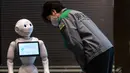 Gubernur Tokyo Yuriko Koike (kanan) melihat robot Pepper saat mengunjungi hotel yang diubah menjadi lokasi karantina pasien COVID-19 di Tokyo, Jepang, Jumat (1/5/2020). Sejumlah hotel di Tokyo mengerahkan robot untuk menyambut pasien COVID-19 dengan gejala ringan. (Philip FONG/AFP)