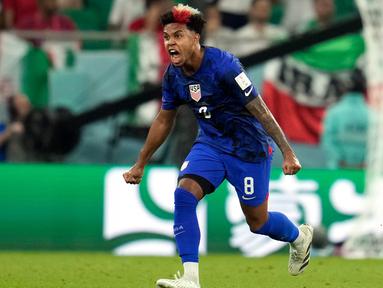 Pemain Amerika Serikat Weston McKennie melakukan selebrasi setelah rekan setimnya Christian Pulisic mencetak gol ke gawang Iran pada pertandingan sepak bola Grup B Piala Dunia 2022 di Stadion Al Thumama, Doha, Qatar, 29 November 2022. Weston McKennie tampil patriotik pada Piala Dunia 2022 dengan mengecat rambutnya dengan warna bendera Amerika Serikat. Gaya rambut Weston McKennie pun langsung menjadi perbincangan di dunia maya. (AP Photo/Ashley Landis)