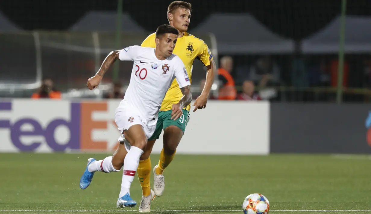 Bek Portugal, Joao Cancelo menggiring bola dari kejaran pemain Lithuania, Karolis Laukzemis pada pertandingan grup B Kualifikasi Euro 2020 di stadion LFF di Vilnius (10/9/2019). Portugal menang telak atas Lithuania 5-1. (AP Photo/Mindaugas Kulbis)