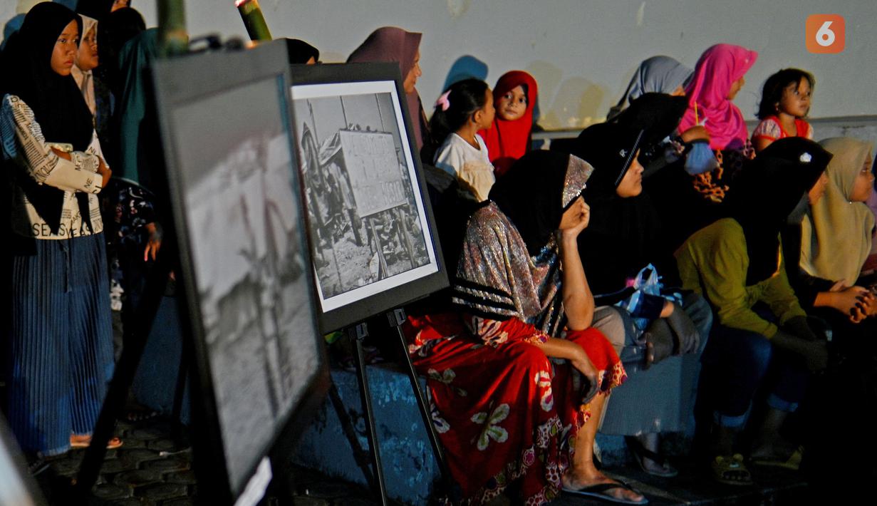 Sejumlah warga menghadiri upacara doa pada malam peringatan 17 tahun tsunami Boxing Day 2004 di monumen Kapal Tsunami Lampulo di Banda Aceh (25/12/2021). (AFP/Chaideer Mahyuddin)