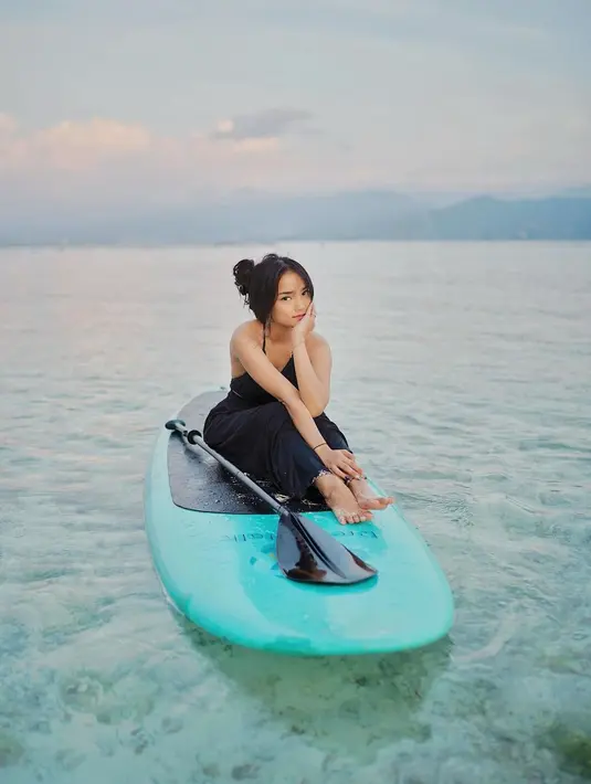 Menikmati waktunya bermain di pantai, Fuji tampil cantik dengan atasan cropped top bertali halter-neck dan celana panjang hitamnya yang serasi. [Foto: Instagram/fuji_an]