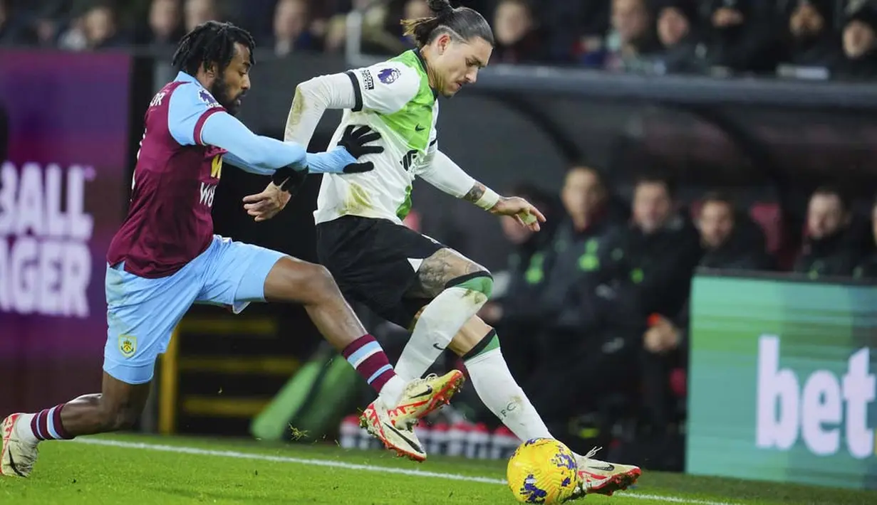 Pemain Liverpool, Darwin Nunez, berebut bola dengan pemain Burnley, Mike Tresor, pada laga pekan ke-19 Premier League 2023/2024 di Stadion Turf Moor, Rabu (27/12/2023). (AP Photo/Jon Super)