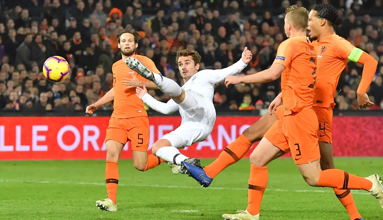Striker Antoine Griezmann menendang bola dari kawalan tiga pemain Belanda selama pertandingan Liga Bangsa-Bangsa UEFA di stadion Feijenoord (16/11/2018). Barcelona siap memboyong Griezmann dengan menebus klausul pelepasannya seharga 125 juta euro (Rp 2,01 triliun). (AFP Photo/Emmanuel Dunand)
