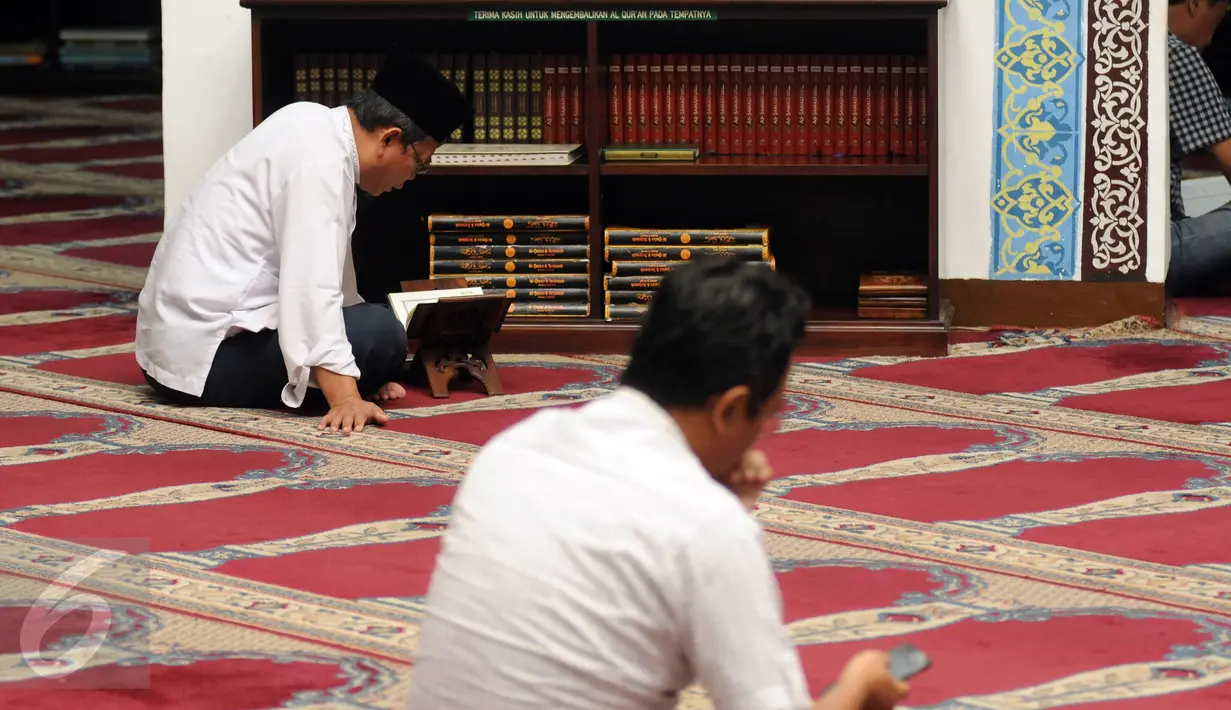 Sejumlah umat muslim bertadarus usai melaksanakan salat di Masjid Cut Meutia, Jakarta, Rabu (15/6/2016). Masjid Cut Meutia memiliki mihrab (tempat imam) yang diletakkan di samping kiri dari saf salat. (Liputan6.com/Helmi Fithriansyah)
