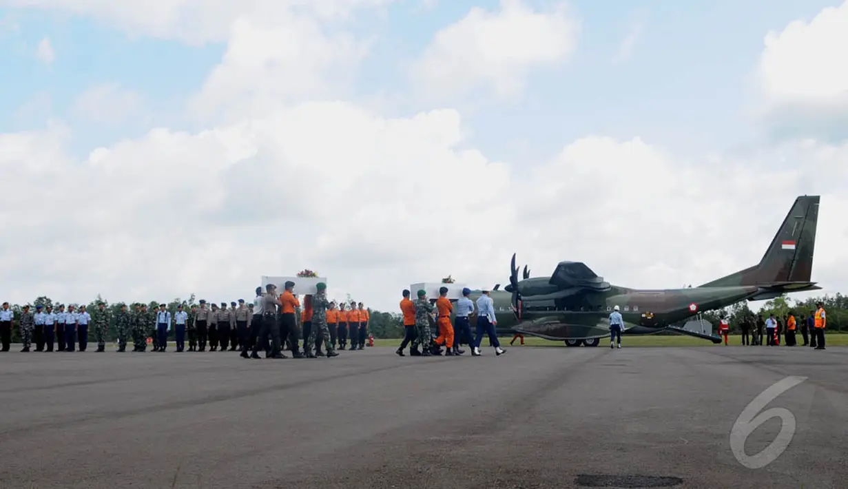 Petugas membawa dua jenazah perempuan korban pesawat AirAsia QZ8501 ke dalam pesawat CN 295 di Lanud Iskandar, Pangkalan Bun, Kalteng, Rabu (7/1/2015). (Liputan6.com/Andrian M Tunay)