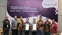 Direktur Enterprise and Business Service Telkom Edi Witjara dan Direktur Utama Bank Papua F. Zendrato (Tengah) melakukan serah terima aplikasi Learning Management System Bank Papua.